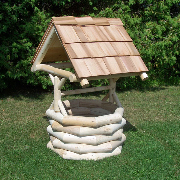 Wooden bird feeder with a roof on a grassy area